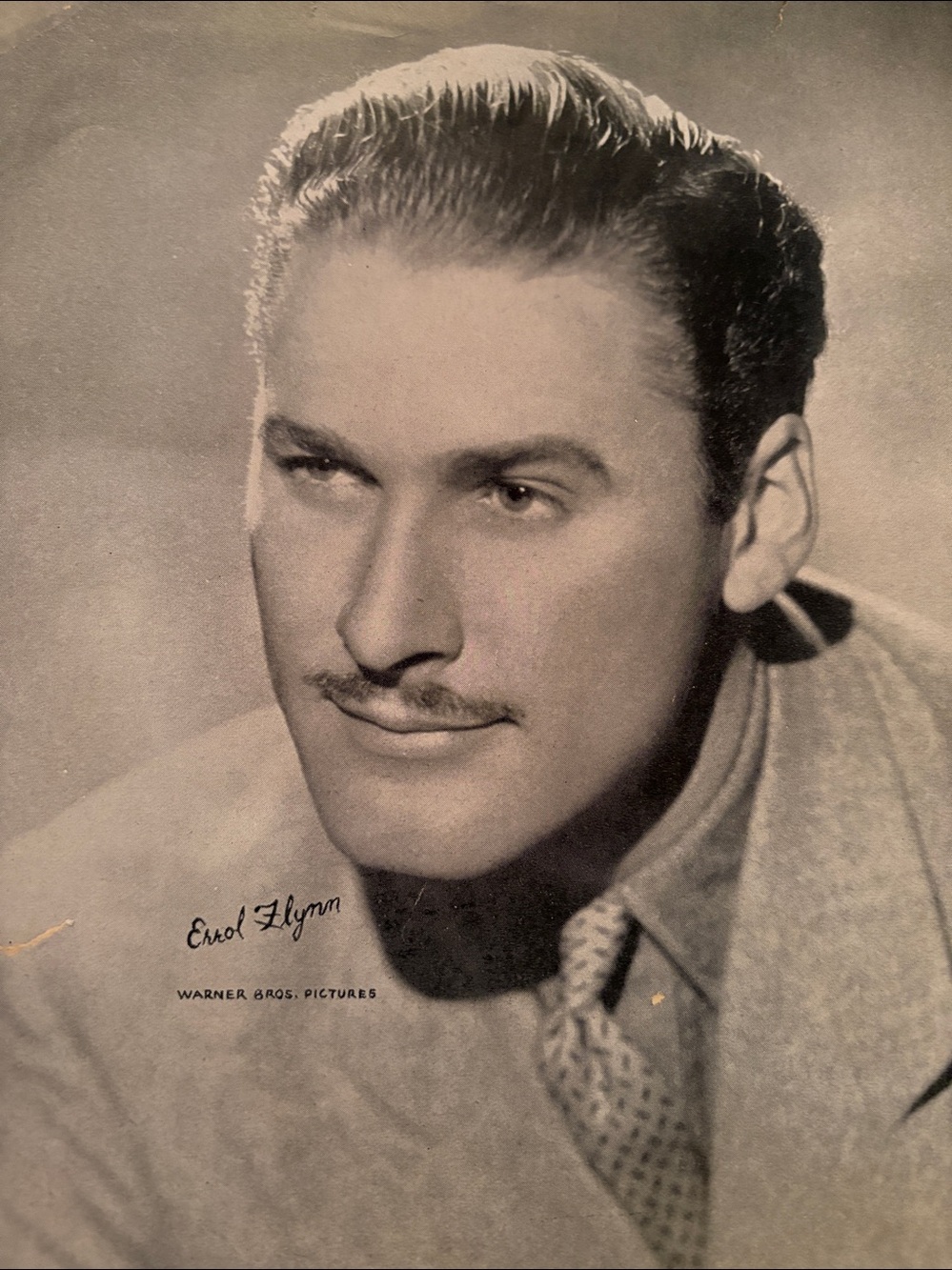 ☑️ A vintage Warner Bros. promotional studio portrait of actor Errol Flynn.